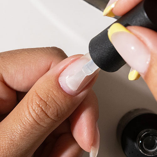 Applying base coat during gel manicure at home - photographed in New Zealand on model
