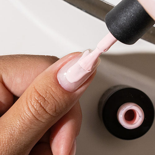 Applying colour coat during gel manicure at home - photographed in New Zealand on model