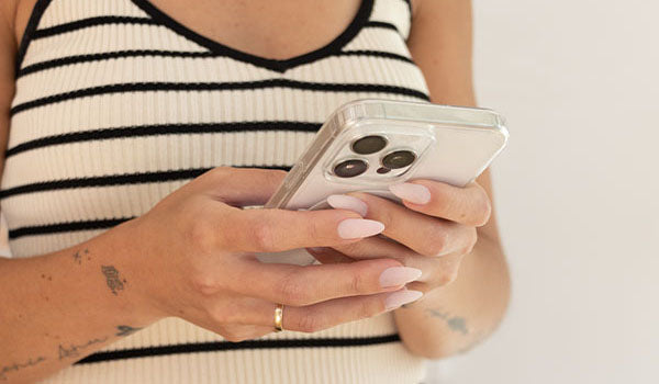 Person holding a smartphone with a white background - photographed in New Zealand