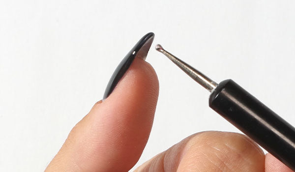 Pointing at a gel nails free edge - photographed in New Zealand on model